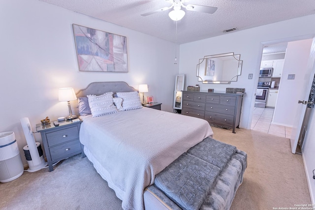 5003 Rustic Rdg, San Antonio, TX 78228 - bedroom featuring light carpet, a textured ceiling, ceiling fan, and connected bathroom
