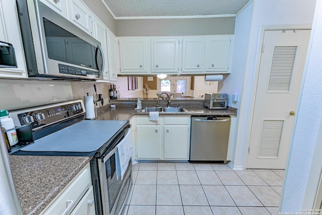 5003 Rustic Rdg, San Antonio, TX 78228 - kitchen featuring appliances with stainless steel finishes, a sink, white cabinets, dark countertops, and crown molding
