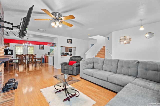 1130 Stone Gdn, New Braunfels, TX 78130 - living room with wood finished floors, a ceiling fan, stairway, a textured ceiling, and a chandelier