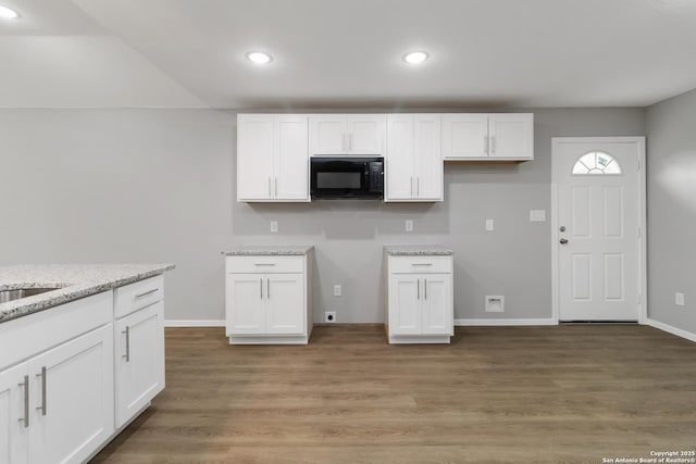 519 W Mitchell, San Antonio, TX 78204 - kitchen featuring black microwave, white cabinets, light stone counters, recessed lighting, and light wood-style flooring