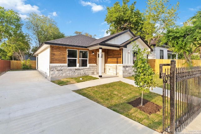 519 W Mitchell, San Antonio, TX 78204 - view of front of house with driveway, a shingled roof, stone siding, and board and batten siding