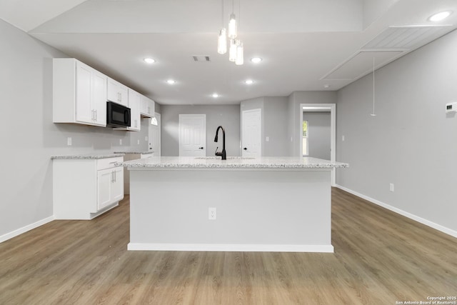 519 W Mitchell, San Antonio, TX 78204 - kitchen with black microwave, a sink, white cabinetry, light wood-style floors, and recessed lighting