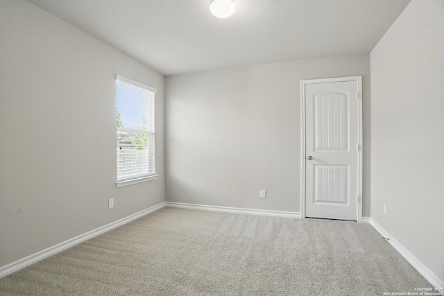 unfurnished room featuring carpet floors and baseboards