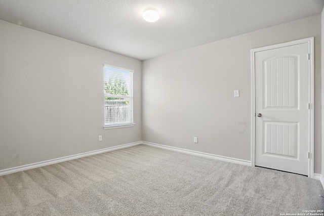unfurnished room featuring carpet and baseboards