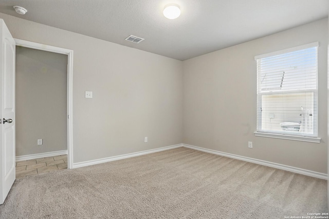 carpeted empty room featuring a smoke detector and baseboards