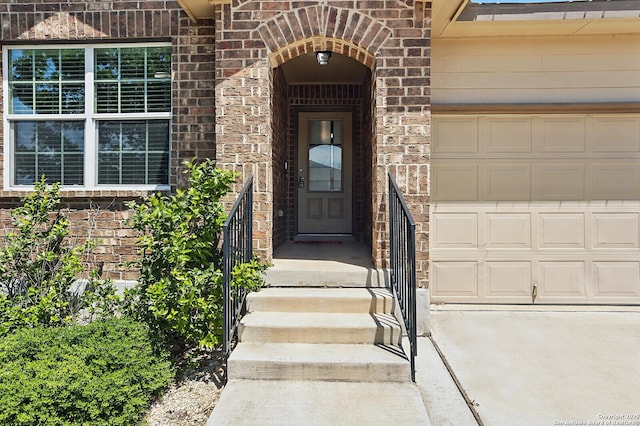 entrance to property with brick siding and a garage