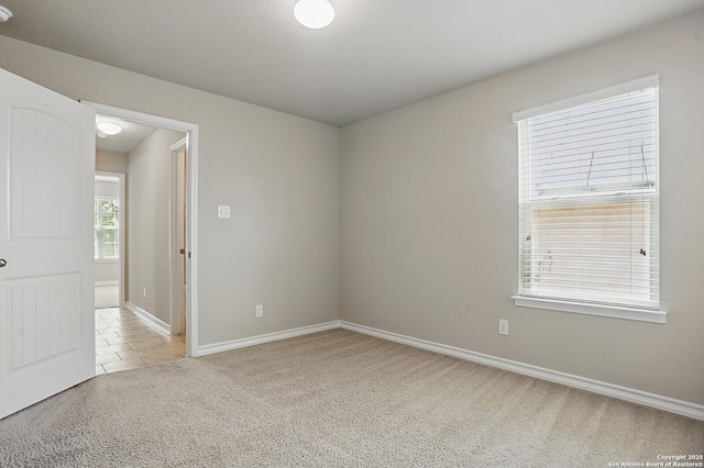tiled spare room with carpet and baseboards
