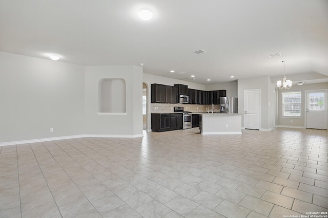 unfurnished living room with a chandelier, baseboards, recessed lighting, and light tile patterned floors