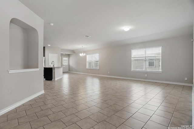 unfurnished living room featuring baseboards, light tile patterned flooring, a sink, a chandelier, and recessed lighting