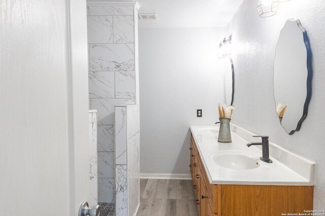 5311 Moreville Farm, San Antonio, TX 78228 - bathroom featuring double vanity, a shower, wood finished floors, and baseboards