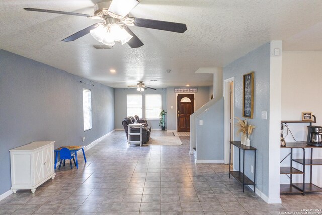 5311 Moreville Farm, San Antonio, TX 78228 - living area with a ceiling fan, a textured ceiling, and baseboards
