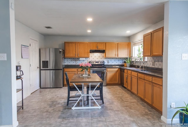 5311 Moreville Farm, San Antonio, TX 78228 - kitchen with appliances with stainless steel finishes, under cabinet range hood, a sink, dark countertops, and backsplash