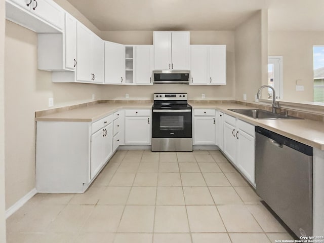 121 Lark Hl, Floresville, TX 78114 - kitchen featuring stainless steel appliances, a sink, light tile patterned flooring, light countertops, and white cabinetry