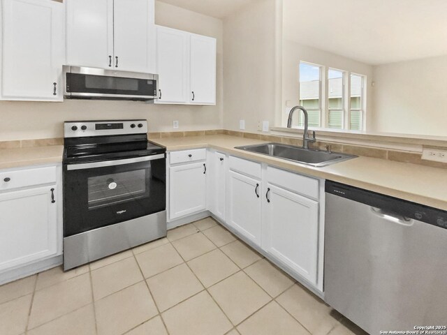 121 Lark Hl, Floresville, TX 78114 - kitchen with stainless steel appliances, a sink, white cabinetry, and light countertops