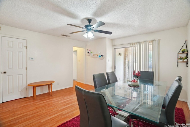 4919 Arbor Rdg, San Antonio, TX 78228 - dining area featuring light wood-type flooring, ceiling fan, a textured ceiling, and baseboards