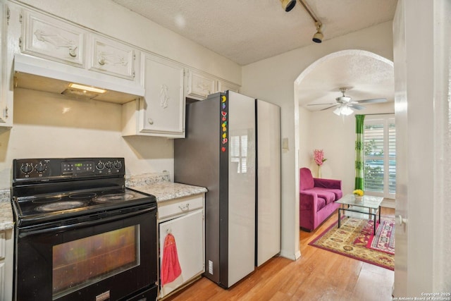 4919 Arbor Rdg, San Antonio, TX 78228 - kitchen with black electric range, freestanding refrigerator, light wood-type flooring, white cabinetry, and a textured ceiling