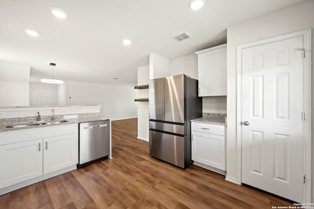6322 Silver Pegasus, San Antonio, TX 78218 - kitchen with appliances with stainless steel finishes, a sink, white cabinetry, dark wood finished floors, and light stone countertops