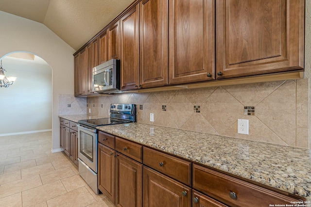 15522 Echo, Selma, TX 78154 - kitchen with appliances with stainless steel finishes, lofted ceiling, decorative backsplash, arched walkways, and light stone counters