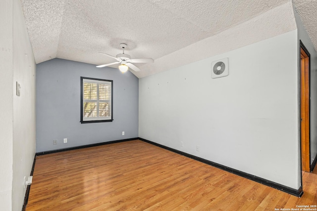9114 Oak Downs Dr, San Antonio, TX 78230 - empty room featuring ceiling fan, wood finished floors, lofted ceiling, a textured ceiling, and baseboards