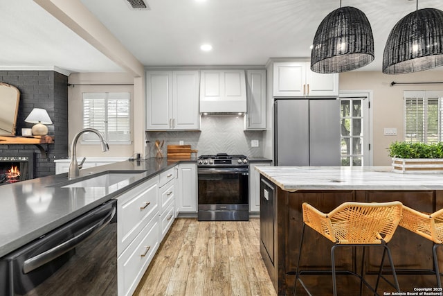 9114 Oak Downs Dr, San Antonio, TX 78230 - kitchen with appliances with stainless steel finishes, a sink, light wood-type flooring, backsplash, and white cabinets