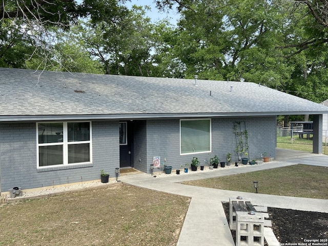326 Riverview, Mcqueeney, TX 78123 - view of front of home featuring a shingled roof, a carport, brick siding, and a front lawn