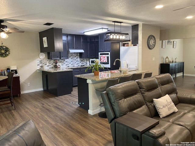 326 Riverview, Mcqueeney, TX 78123 - kitchen featuring white appliances, blue cabinetry, tasteful backsplash, a sink, and ceiling fan