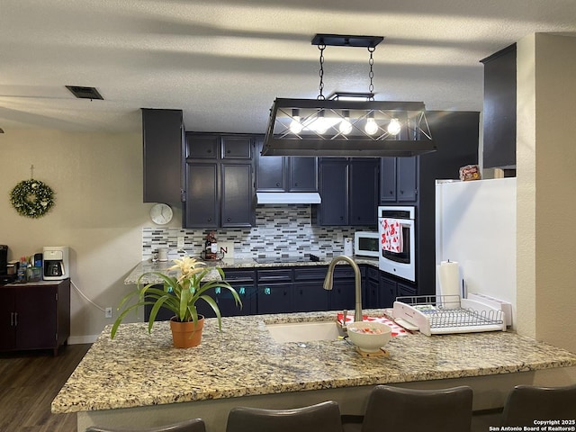 326 Riverview, Mcqueeney, TX 78123 - kitchen featuring white appliances, a sink, a breakfast bar area, and dark wood finished floors