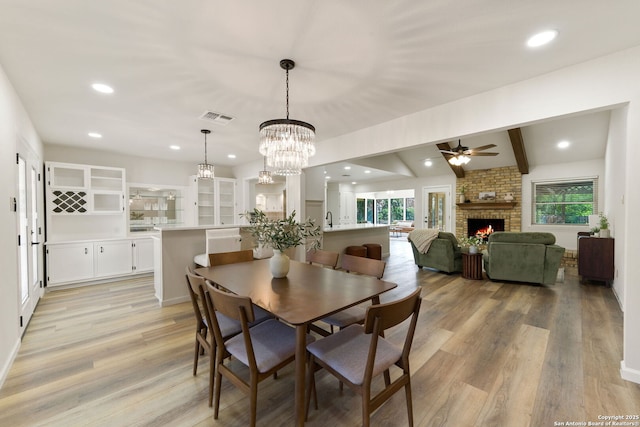 430 Yosemite Dr, San Antonio, TX 78232 - dining room with healthy amount of natural light, a ceiling fan, a brick fireplace, light wood finished floors, and recessed lighting