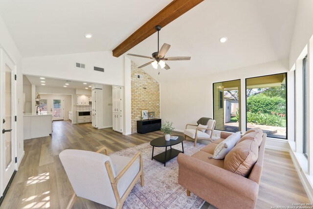 430 Yosemite Dr, San Antonio, TX 78232 - living area featuring light wood finished floors, plenty of natural light, beamed ceiling, a ceiling fan, and a fireplace