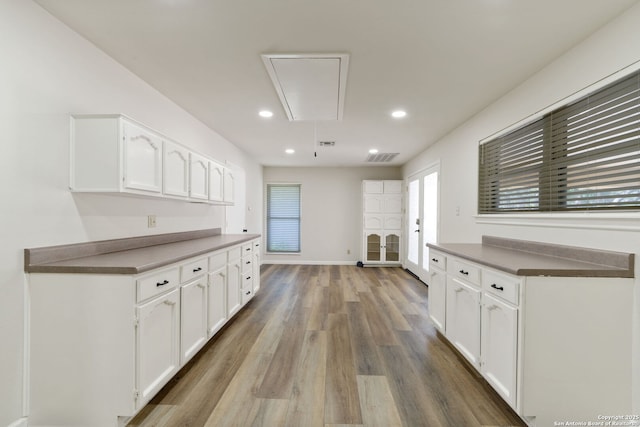 430 Yosemite Dr, San Antonio, TX 78232 - kitchen with wood finished floors, white cabinets, recessed lighting, baseboards, and dark countertops