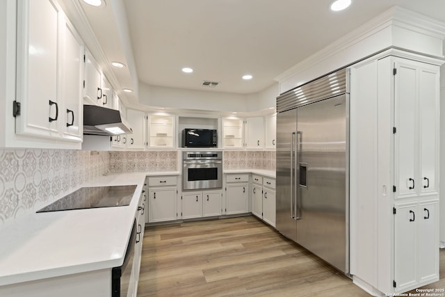 430 Yosemite Dr, San Antonio, TX 78232 - kitchen with stainless steel appliances, under cabinet range hood, light wood finished floors, recessed lighting, and white cabinets