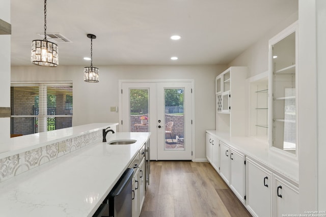 430 Yosemite Dr, San Antonio, TX 78232 - kitchen with a sink, light wood-style floors, french doors, white cabinetry, and decorative light fixtures