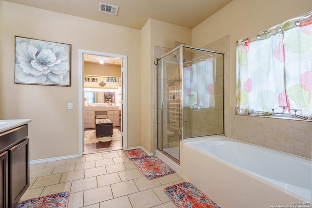 11607 Pelican Pass, San Antonio, TX 78221 - full bath featuring vanity, a shower stall, a bath, and tile patterned floors