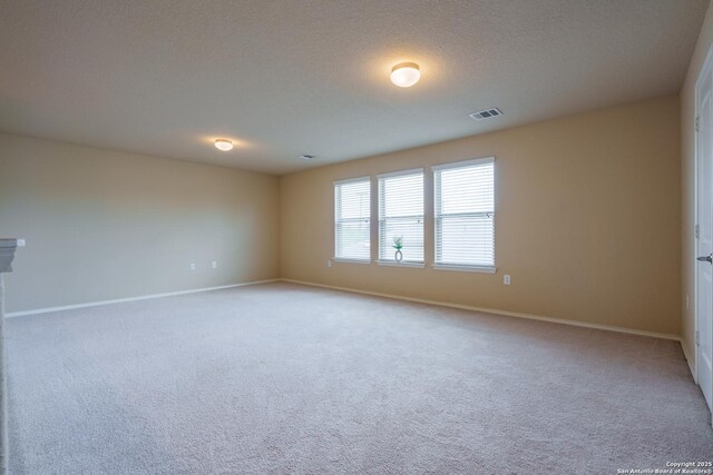 11607 Pelican Pass, San Antonio, TX 78221 - empty room with light colored carpet, baseboards, and a textured ceiling