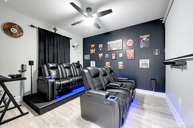 149 Chisum Ln, Vernia, TX 78121 - cinema room featuring a ceiling fan, light wood finished floors, an accent wall, and baseboards
