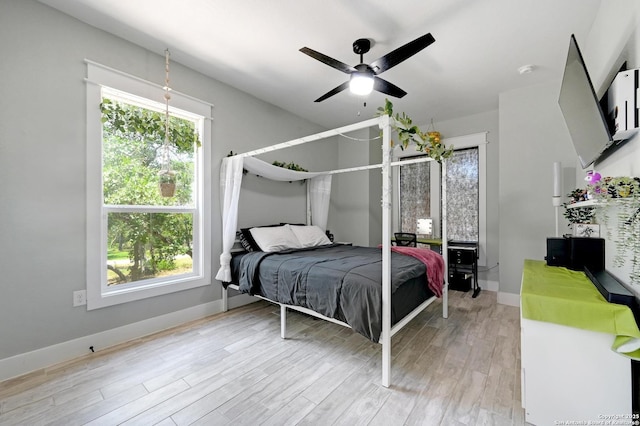 149 Chisum Ln, Vernia, TX 78121 - bedroom featuring multiple windows, light wood-style floors, and baseboards