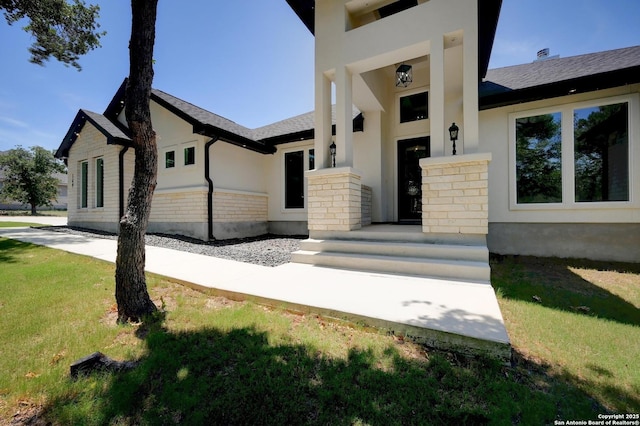 149 Chisum Ln, Vernia, TX 78121 - doorway to property featuring stucco siding, a yard, and stone siding