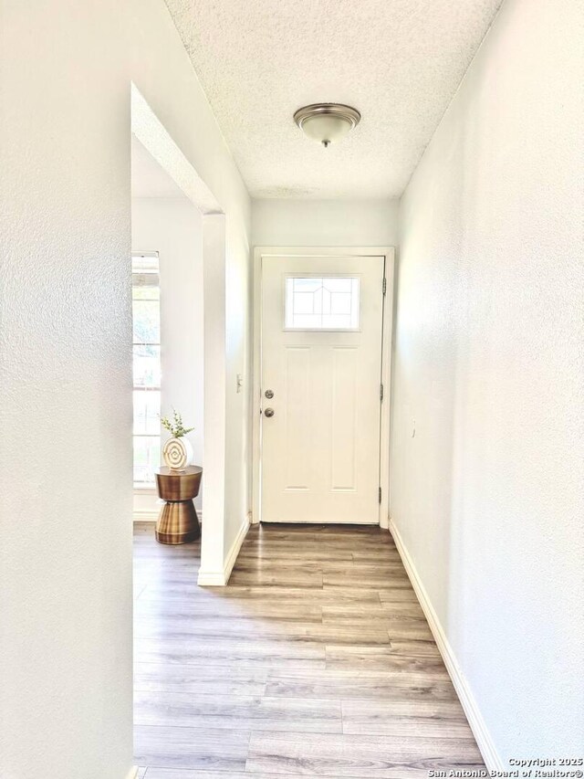 1303 Billings Dr, San Antonio, TX 78245 - entryway with light wood-style flooring, a textured ceiling, baseboards, and a textured wall