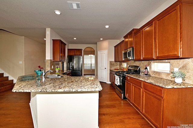 14402 Palomino Pl, San Antonio, TX 78254 - kitchen featuring stainless steel appliances, a sink, a peninsula, dark wood-type flooring, and light stone counters