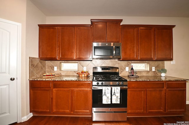 14402 Palomino Pl, San Antonio, TX 78254 - kitchen featuring appliances with stainless steel finishes, stone countertops, dark wood-style flooring, and decorative backsplash