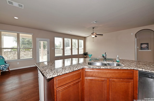 14402 Palomino Pl, San Antonio, TX 78254 - kitchen with stainless steel dishwasher, a sink, dark wood finished floors, brown cabinetry, and light stone countertops