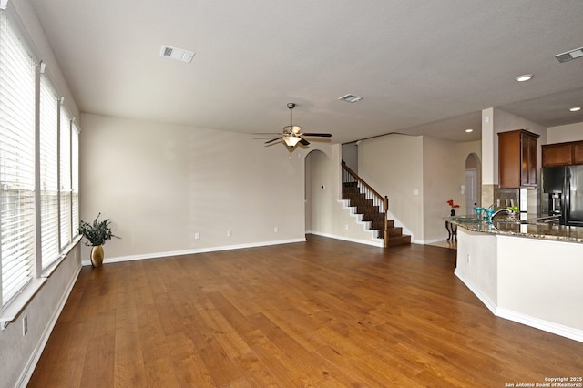 14402 Palomino Pl, San Antonio, TX 78254 - unfurnished living room featuring arched walkways, wood finished floors, a ceiling fan, stairway, and recessed lighting
