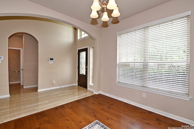 14402 Palomino Pl, San Antonio, TX 78254 - entrance foyer featuring a chandelier, baseboards, wood finished floors, and arched walkways