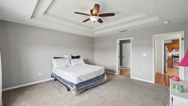 1070 Northpark, New Braunfels, TX 78130 - bedroom with a tray ceiling, freestanding refrigerator, light colored carpet, a ceiling fan, and baseboards