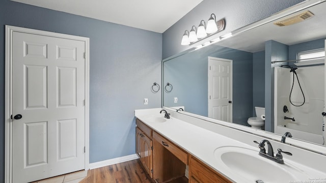 1070 Northpark, New Braunfels, TX 78130 - full bathroom featuring toilet, double vanity, wood finished floors, baseboards, and shower / bath combination