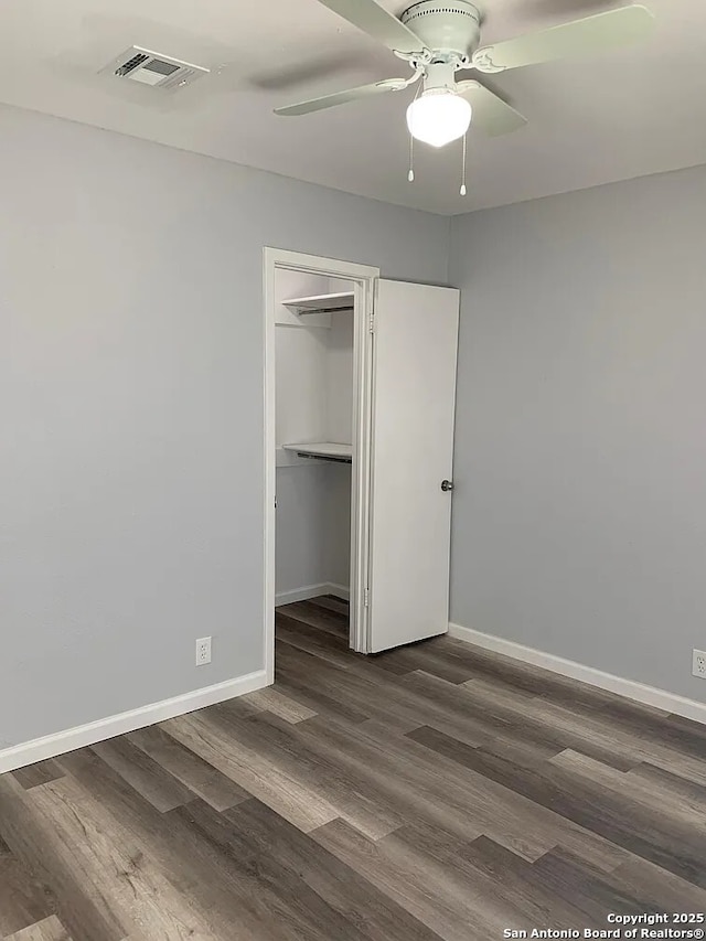 5135 Tom Stafford, Kirby, TX 78219 - unfurnished bedroom with dark wood-style floors, baseboards, a closet, ceiling fan, and a spacious closet