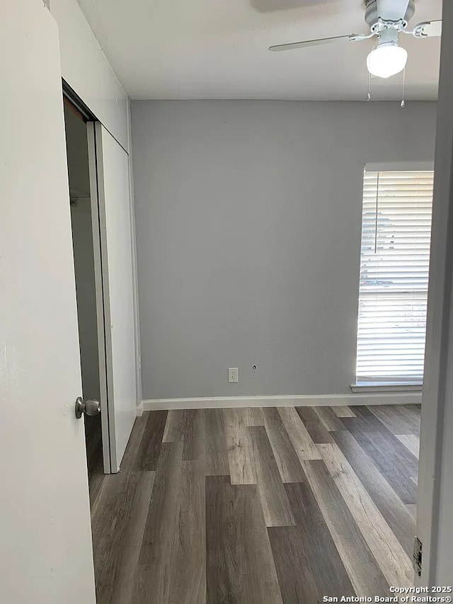 5135 Tom Stafford, Kirby, TX 78219 - unfurnished bedroom with dark wood-style flooring, ceiling fan, baseboards, and a closet