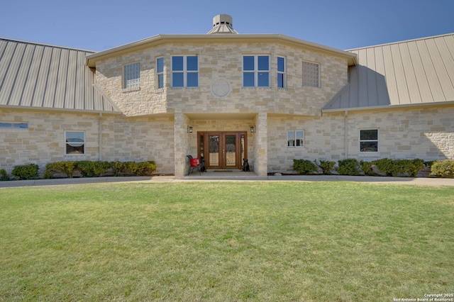 24005 Pedernales Canyon Trl, Spicewood, TX 78669 - view of front of property featuring french doors, a standing seam roof, a front yard, metal roof, and stone siding