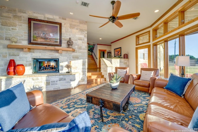 24005 Pedernales Canyon Trl, Spicewood, TX 78669 - living room with a stone fireplace, ornamental molding, a ceiling fan, wood finished floors, and stairs