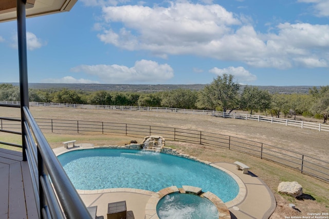 24005 Pedernales Canyon Trl, Spicewood, TX 78669 - view of swimming pool with a view of countryside, a pool with connected hot tub, and fence